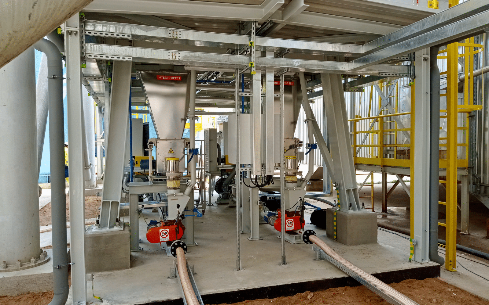 Modernisierte InterProcess-Dosierer unter Silos in einem Produktionsbetrieb